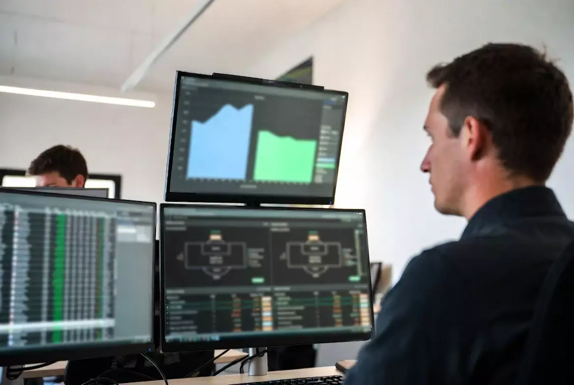 Analyst arbeitet an mehreren Bildschirmen mit Fußballdaten