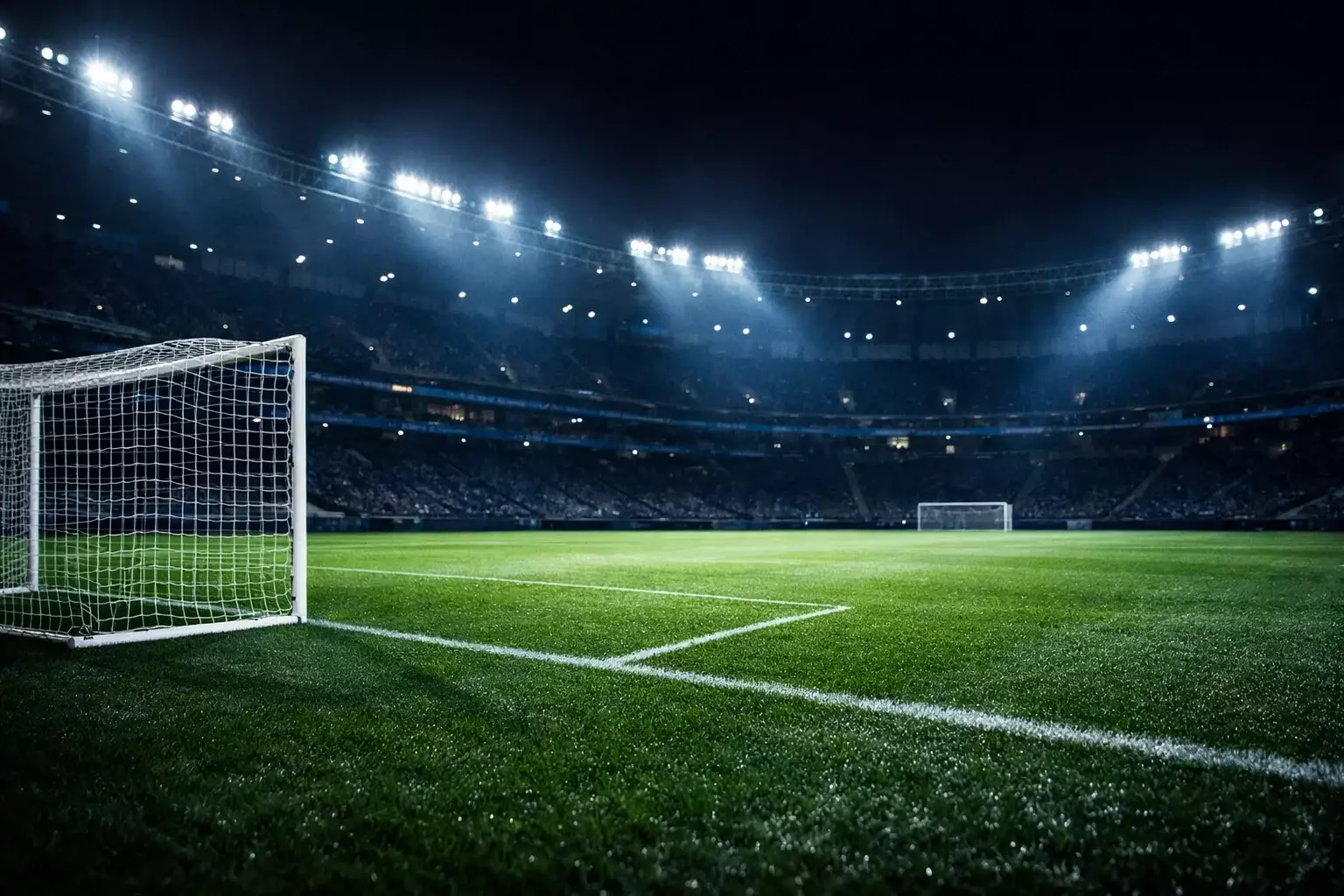 Beleuchtetes Champions-League-Stadion bei Nacht mit gruenem Rasen