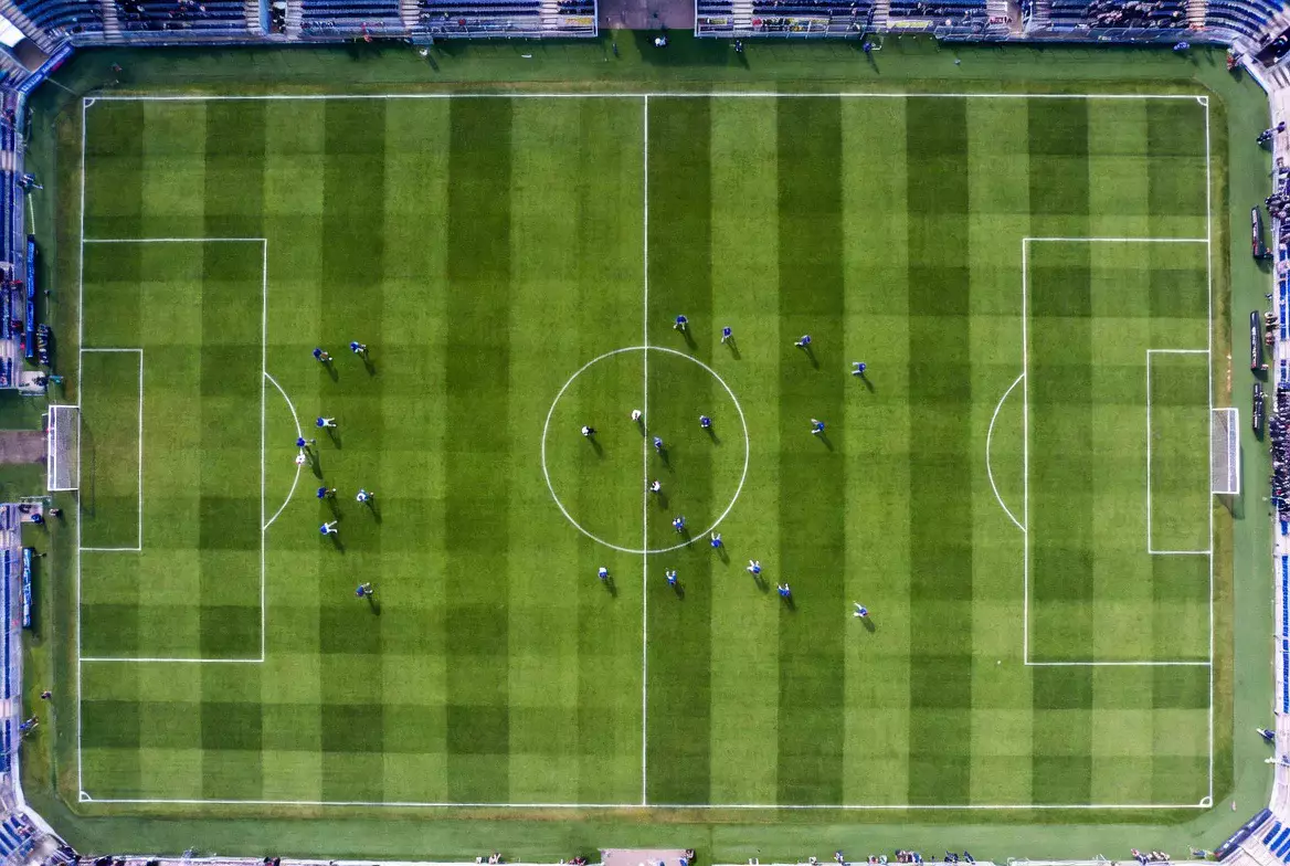 Fußballfeld aus der Vogelperspektive mit Spielern
