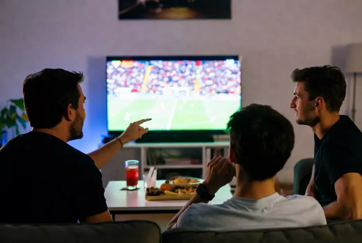 Menschen schauen gemeinsam ein Fußballspiel im Fernsehen